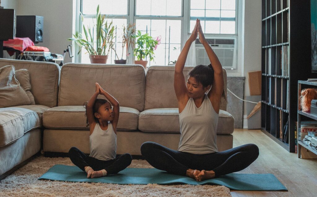 woman doing yoga with a little girl